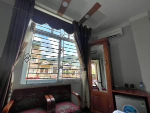 una ventana en una habitación con un sofá delante en Thái Thịnh Hotel, en Dồng Văn