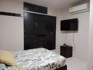 een slaapkamer met een bed en een grote zwarte kast bij Confortable Aparta Estudio al Norte in Neiva