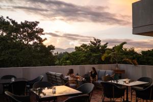 Dos mujeres sentadas en un patio con mesas y sillas en Hotel Dumaguete, en Dumaguete