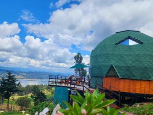 een koepelhuis met een terras en uitzicht op een meer bij Glamping sede campestre Mirador de Pueblo Viejo in Guatavita
