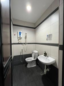 a bathroom with a toilet and a sink at Jb Sojourn in Skudai