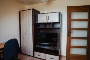 Zimmer mit einem TV und einem Schrank mit einer Tür in der Unterkunft Gospodarstwo Agroturystyczne ZACISZE 