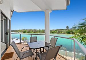 - un balcon avec une table, des chaises et l'eau dans l'établissement Sunrise Cove Holiday Apartments by Kingscliff Accommodation, à Kingscliff