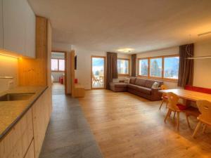 eine Küche und ein Wohnzimmer mit einem Tisch und einem Sofa in der Unterkunft Holiday apartment in St Lorenzen in Floronzo