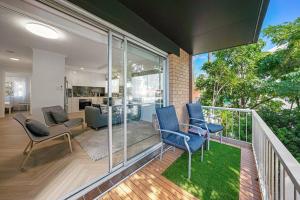 a living room with blue chairs on a balcony at Stylish 2BR Unit in Southport in Gold Coast
