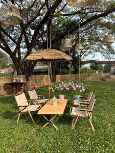 a group of chairs and a table and umbrella at Peang Tara Cafe & Resort in Nong Khai