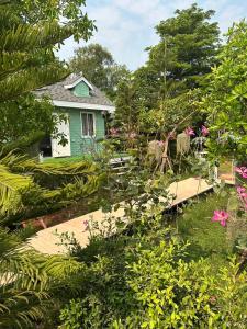 una casa verde en medio de un jardín en Peang Tara Cafe & Resort en Nong Khai