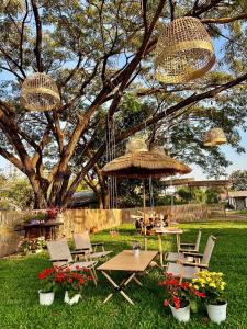 a group of tables and chairs with umbrellas and flowers at Peang Tara Cafe & Resort in Nong Khai