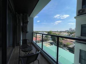 安吉利斯High Class 1BR at One Euphoria的阳台配有两把椅子,享有网球场的景色