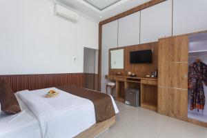 a hotel room with a bed and a tv at Samuh Sunset Nusa Penida by Pramana Villas in Nusa Penida