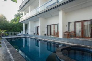 a swimming pool in front of a house at Samuh Sunset Nusa Penida by Pramana Villas in Nusa Penida