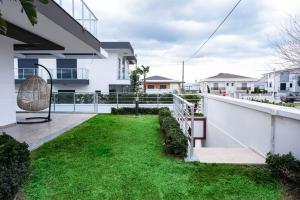 einen Balkon eines Hauses mit grünem Gras in der Unterkunft Havuzlu lüks yeni 4 oda in Cesme