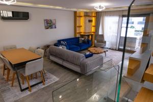 ein Wohnzimmer mit einem Sofa und einem Tisch in der Unterkunft Havuzlu lüks yeni 4 oda in Cesme