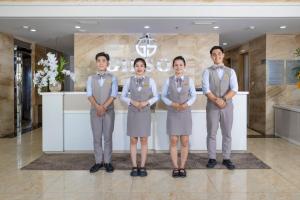 um grupo de quatro pessoas em pé em um lobby em Gibson Hotel Nha Trang em Nha Trang