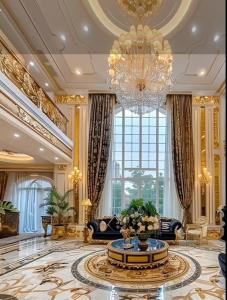 The Empress Palace Hotel في سوري: غرفة معيشة كبيرة فيها ثريا وسجادة كبيرة