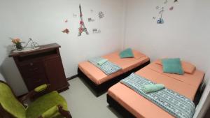 een kamer met 2 aparte bedden en een stoel bij Apartamento central - Villa Xiomara in Santa Rosa de Cabal