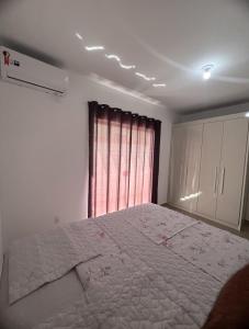 Un dormitorio con una cama grande y una ventana en Ap 2 quartos climatizados 5min Praia de BC acesso as Praias, en Camboriú