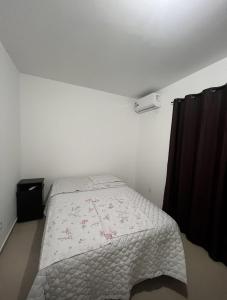 Un pequeño dormitorio blanco con una cama en una habitación en Ap 2 quartos climatizados 5min Praia de BC acesso as Praias, en Camboriú
