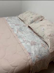 Una cama con un edredón con flores. en Ap 2 quartos climatizados 5min Praia de BC acesso as Praias, en Camboriú