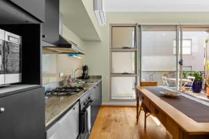 uma cozinha com um fogão e uma bancada em 'Laube 105' Modern Inner-city Sanctuary with Balcony em Sydney