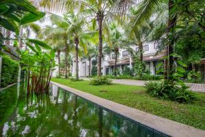 a resort with a pool in front of a building at Lotus Blanc Resort in Siem Reap
