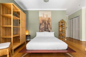 1 dormitorio con 1 cama y una pintura de una ciudad en 'Laube 105' Modern Inner-city Sanctuary with Balcony en Sídney
