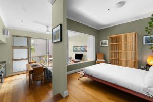 una camera con letto, scrivania e tavolo di 'Laube 105' Modern Inner-city Sanctuary with Balcony a Sydney