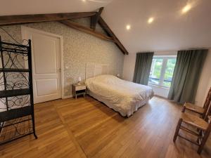 een slaapkamer met een bed en een houten vloer bij LE RELAIS VAUBAN 