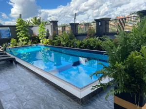 ein Swimmingpool mit blauem Wasser im Garten in der Unterkunft CosyNook in Kigali