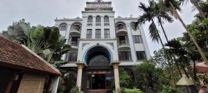 un edificio bianco con una torre dell'orologio in cima di Thap Tam Royal Hotel a Ninh Binh