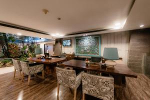 a dining room with a wooden table and chairs at Amaroossa Suite Bali in Nusa Dua