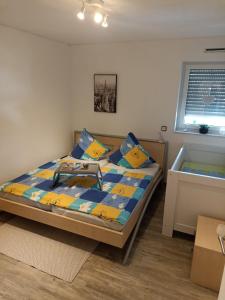 1 dormitorio con 1 cama con almohadas azules y amarillas en Apart Bellagast, en Hilchenbach
