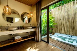 a bathroom with two sinks and a bath tub at Bandara Spa Resort & Pool Villas, Samui in Bophut