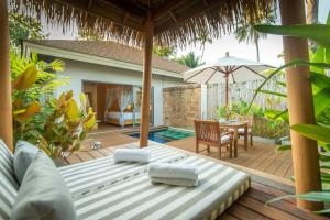 a patio with a bed and a table and an umbrella at Bandara Spa Resort & Pool Villas, Samui in Bophut