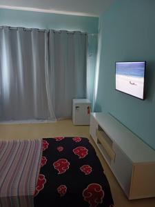 a bedroom with a bed and a flat screen tv at Suíte Palace in Rio de Janeiro