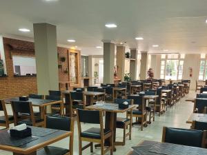 une salle à manger avec des tables et des chaises dans l'établissement Condomínio Resort na cidade das águas sulfurosas, à Poços de Caldas