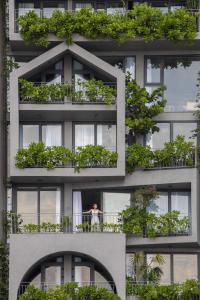 un bâtiment avec de nombreuses plantes sur les balcons dans l'établissement Leaf Beachfront Hotel Da Nang, à Đà Nẵng