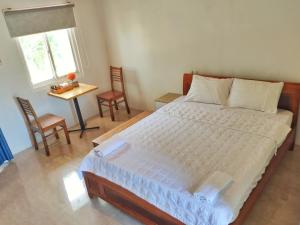 1 dormitorio con 1 cama, mesa y sillas en Biển Xanh Homestay en Ly Son