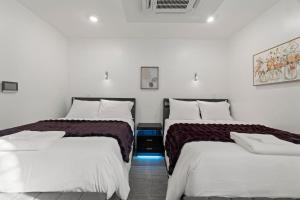 two beds in a room with white walls at New Season Royals, Airport West in Chester