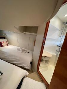 um pequeno quarto com uma cama e um espelho em Motor Boat Accommodation em Torquay