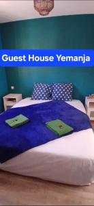 a bed in a room with a guest house seminar sign at Guest House Yemanja in Narbonne