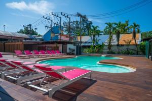 una piscina con sillas y una montaña rusa en Base Ao Nang Beachfront Hostel, en Ao Nang Beach