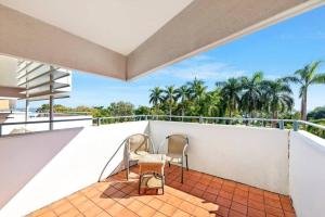 2 sedie su un balcone con palme di 'Towering Palms' Resort-style Stay with a Separate Studio a Darwin