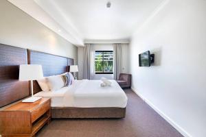 Uma cama ou camas num quarto em 'Towering Palms' Resort-style Apartment with a Separate Studio