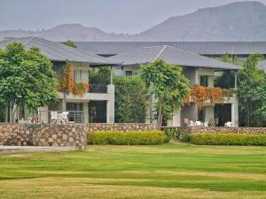 a house with a retaining wall and a yard at TatSaraasa Resort & Spa, Udaipur in Udaipur