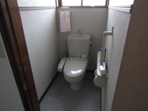 a small bathroom with a toilet and a window at Yuzawa Condo 一棟貸 貴重な駐車場2台無料 in Yuzawa