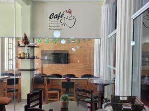 Condomínio Resort na cidade das águas sulfurosas في بوكوس دي كالداس: مطعم بطاولات وكراسي وعلامة تفاح على الحائط