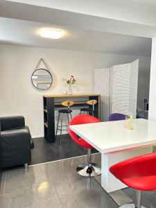 にあるFe Wo Auf der Albの赤い椅子と白いテーブルが備わる客室です。