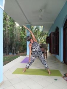 une personne faisant une pose de yoga dans une maison dans l'établissement Lagoon Apartments Beruwala, à Beruwala