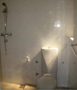 ein weißes Bad mit einem WC und einer Dusche in der Unterkunft Lagoon Apartments Beruwala in Beruwala